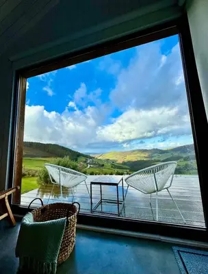 a room with a large window looking out onto a lake at Cabañas Huma 2 in Vegadeo
