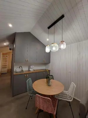 a kitchen with a table and chairs and lights at Cabañas Huma 2 in Vegadeo