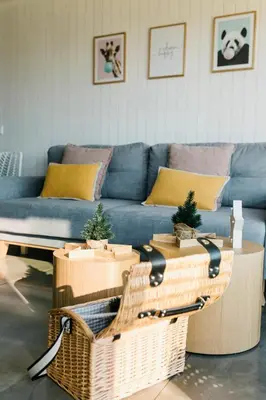 a living room with a blue couch and wicker tables at Cabañas Huma 2 in Vegadeo