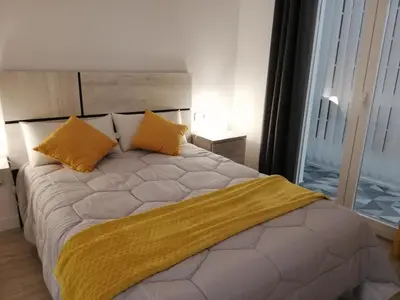a bedroom with a large bed with yellow pillows at Piso Ourense Centro in Ourense