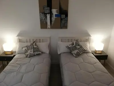 two beds in a room with two lamps on tables at Piso Ourense Centro in Ourense