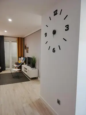 a living room with a clock on the wall at Piso Ourense Centro in Ourense
