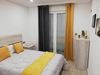 a bedroom with a large bed with yellow pillows at Piso Ourense Centro in Ourense