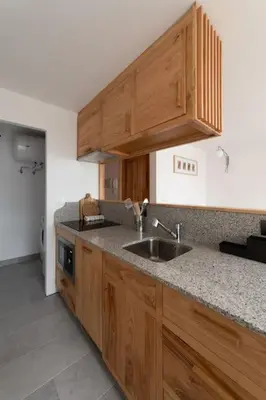 a kitchen with wooden cabinets and a sink at Ferreiros - Wood Design apartments in Puentedeume