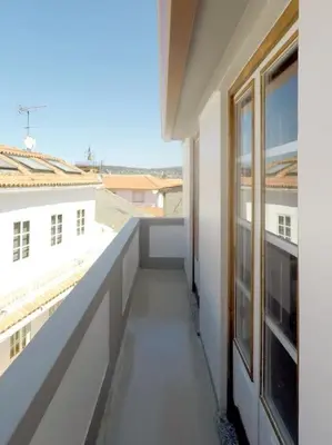 a balcony of a white building with a window at Ferreiros - Wood Design apartments in Puentedeume