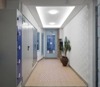 a hallway with blue doors and a potted plant at Apartamentos Turísticos As Burgas 6 by Bossh! Hotels in Ourense