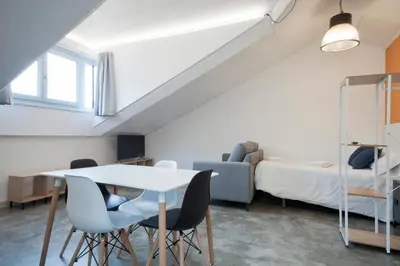 a room with a table and chairs and a bed at Apartamentos Turísticos As Burgas 6 by Bossh! Hotels in Ourense