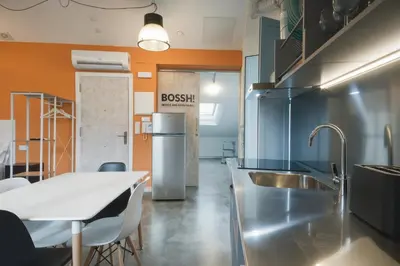 a kitchen with stainless steel appliances and a table at Apartamentos Turísticos As Burgas 6 by Bossh! Hotels in Ourense