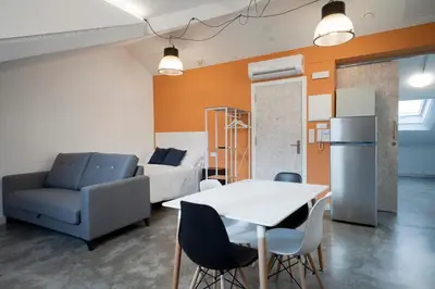 a living room with a couch and a table and chairs at Apartamentos Turísticos As Burgas 6 by Bossh! Hotels in Ourense