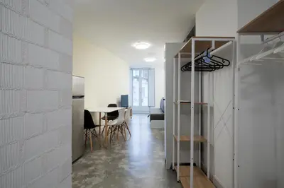 a kitchen and dining room with a white brick wall at Apartamentos Turísticos As Burgas 6 by Bossh! Hotels in Ourense