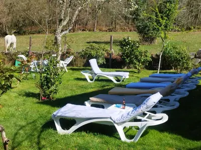 a group of chairs and lounge chairs in the grass at Casa Da Vieira in Ourense