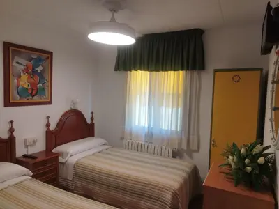 a hotel room with two beds and a window at Casa Da Vieira in Ourense