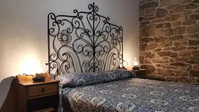a bedroom with a bed and a stone wall at Casa do Castiro in Palas de Rei