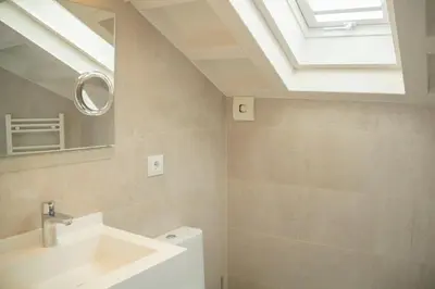 a bathroom with a white sink and a skylight at Hotel Alda San Bieito in Santiago de Compostela