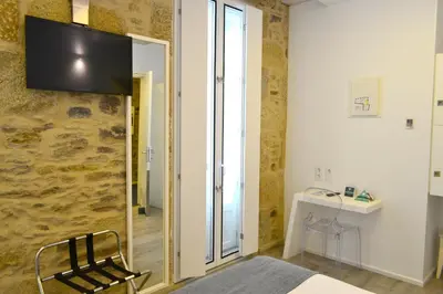 a room with a chair and a television on the wall at Hotel Alda San Bieito in Santiago de Compostela