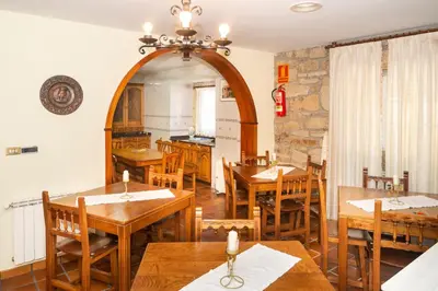 a dining room with wooden tables and chairs at Casa Ravel in Silleda
