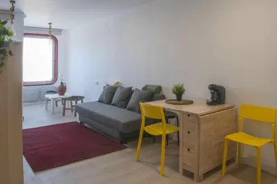 a living room with a couch and a tv and a kitchen at Ciudad Coruña Estación Manzaneda in Prada