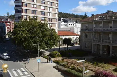 a group of people walking down a city street at Las Palmeras in Caldas de Reis