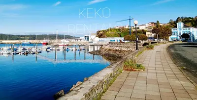 a walkway next to a marina with boats in the water at Casa do Xuli in Viveiro