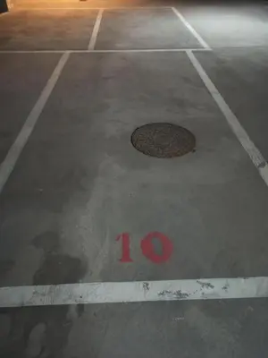 a manhole cover in a parking lot with the number at Casa do Xuli in Viveiro