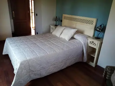 a bedroom with a large white bed with two night stands at Quinta da Rocha in Crecíente
