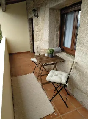 a patio with a wooden table and two chairs at Quinta da Rocha in Crecíente
