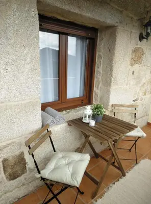 a wooden table and two chairs in front of a window at Quinta da Rocha in Crecíente