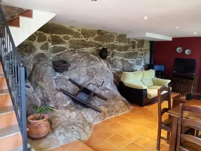 a living room with a large stone fireplace at Quinta da Rocha in Crecíente