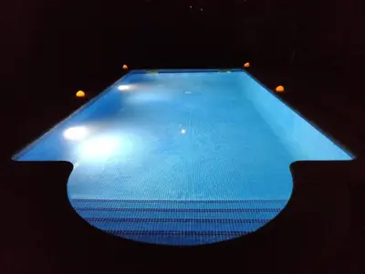 a large blue swimming pool with lights on it at Quinta da Rocha in Crecíente