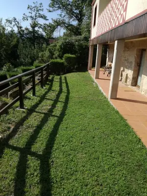 a shadow of a fence on the grass next to a building at Quinta da Rocha in Crecíente
