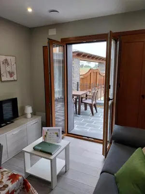 a living room with a couch and a sliding glass door at El Rato Apartamentos Rurales in Navia
