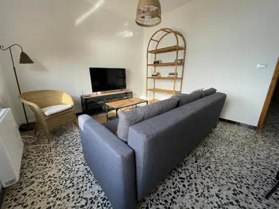 a living room with a blue couch and a tv at Oktheway Perbes Beach Vintage in Boebre