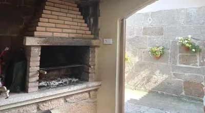a brick fireplace in a room with a window at O Balcon Do Oitaven, vuestra finca privada en Galicia in Pontevedra