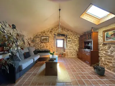 a living room with a couch and a stone wall at O Balcon Do Oitaven, vuestra finca privada en Galicia in Pontevedra