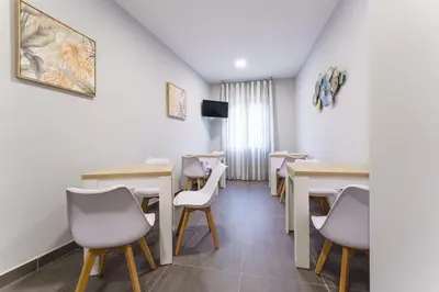 a dining room with tables and chairs and a tv at PENSIÓN CASA ELENA *** in Arzúa