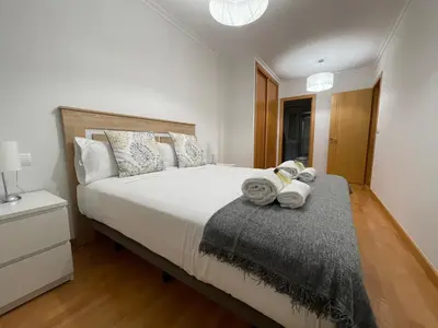 a bedroom with a large white bed with a night stand at OKTHEWAY Castelao Street in Sarria