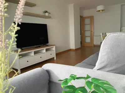 a living room with a table and a couch at OKTHEWAY Castelao Street in Sarria