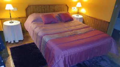 a bedroom with a large bed with two lamps at Rectoral de Prado in Piñeiro