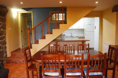 a kitchen and dining room with a table and a staircase at Rectoral de Prado in Piñeiro