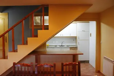 a staircase in a kitchen with a table and chairs at Rectoral de Prado in Piñeiro