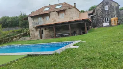 a house with a swimming pool in front of it at Rectoral de Prado in Piñeiro
