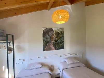 two beds in a room with a painting on the wall at Apartamentos Turísticos VillaCordido Villaframil Ribadeo in Ribadeo