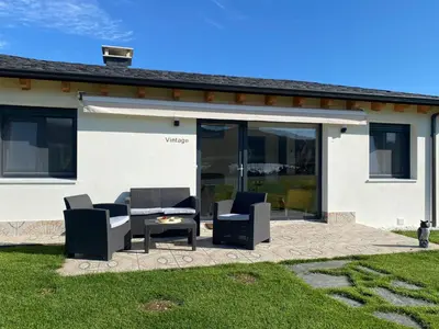 a patio with chairs and a table in front of a house at Apartamentos Turísticos VillaCordido Villaframil Ribadeo in Ribadeo
