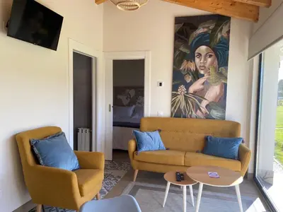 a living room with a couch and a painting on the wall at Apartamentos Turísticos VillaCordido Villaframil Ribadeo in Ribadeo