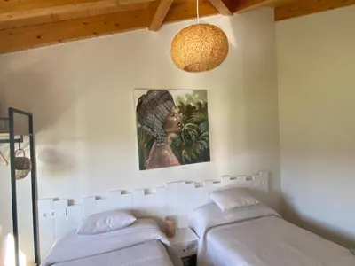 a bedroom with two beds and a painting on the wall at Apartamentos Turísticos VillaCordido Villaframil Ribadeo in Ribadeo