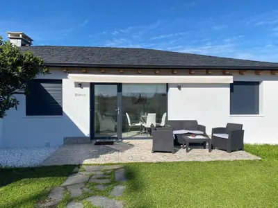 a patio with chairs and a table in front of a house at Apartamentos Turísticos VillaCordido Villaframil Ribadeo in Ribadeo