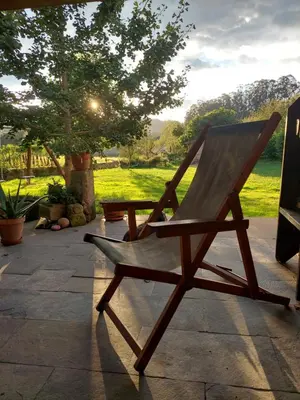 a wooden rocking chair sitting on a patio at Casetón do Forno. in Lourenzá
