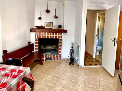 a living room with a fireplace and a bed at CASA NARCISA - Perfecta para familias y grupos - Valle del Silencio in San Clemente de Valdueza