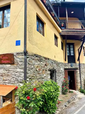 a stone building with flowers in front of it at CASA NARCISA - Perfecta para familias y grupos - Valle del Silencio in San Clemente de Valdueza