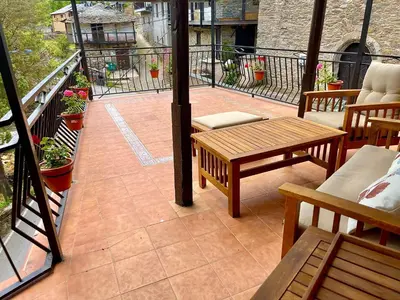 a patio with benches and tables on a balcony at CASA NARCISA - Perfecta para familias y grupos - Valle del Silencio in San Clemente de Valdueza